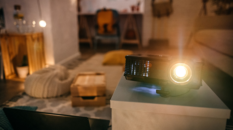 A projector propped on a table inside a living room