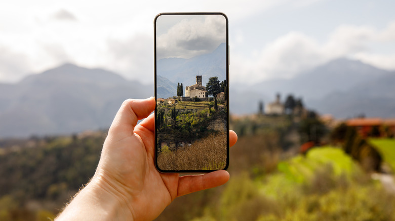 Close-up of person's hand as they take photo with phone
