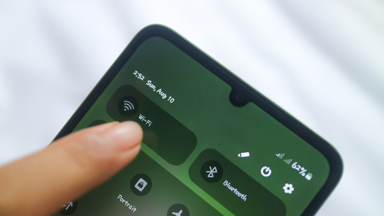 Selecting Wi-Fi toggle on Android phone from quick settings menu.