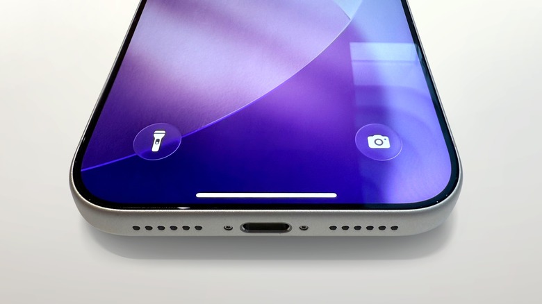 iPhone on white table showing flashlight and camera icons at bottom of screen