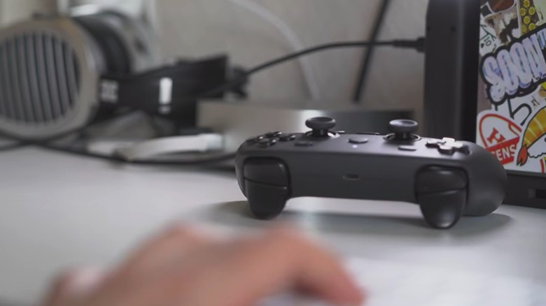 Steam Controller rumbling around on table with hand and keyboard in foreground