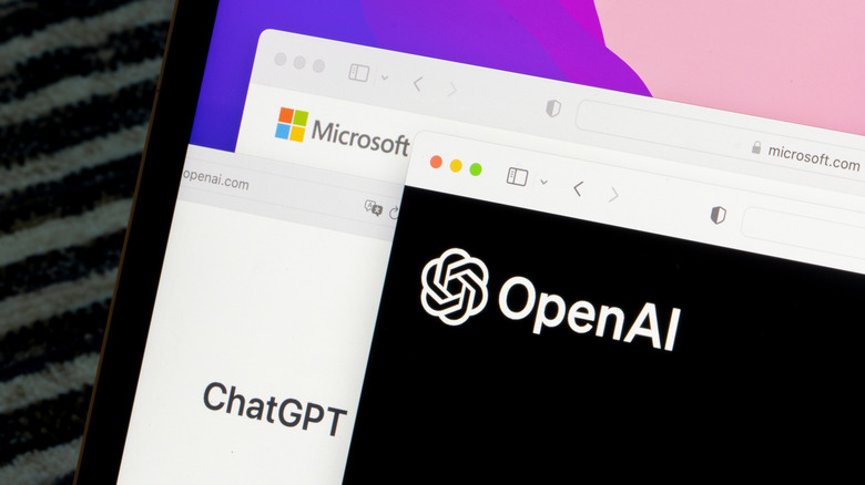 A photo of a photo of the OpenAI logo along with the ChatGPT Logo and Microsoft Logo on a laptop monitor.