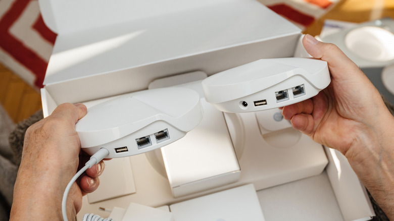 Close-up of a person unboxing a mesh Wi-Fi system