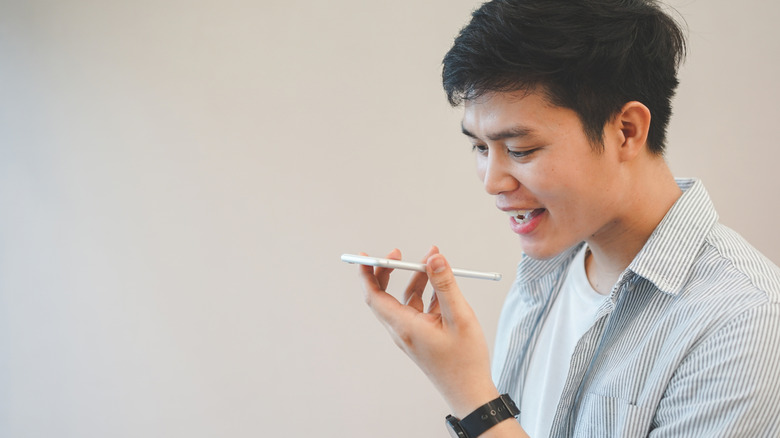 person talking into smartphone, concept of using real-time translation