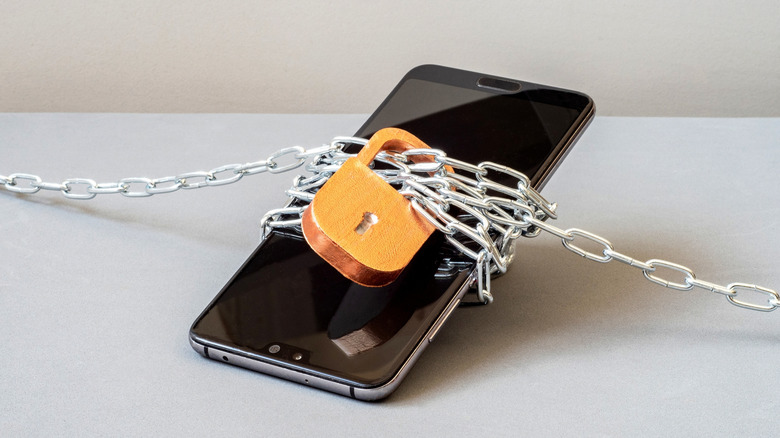 Close up of a smartphone locked in chains and a lock