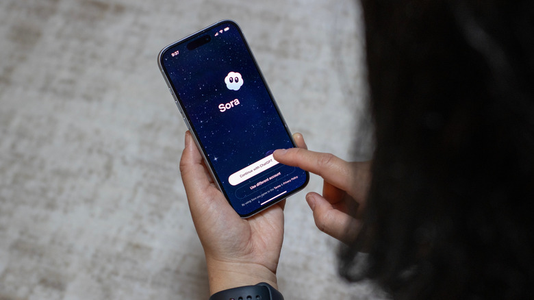 Person logging into Sora app on their smartphone