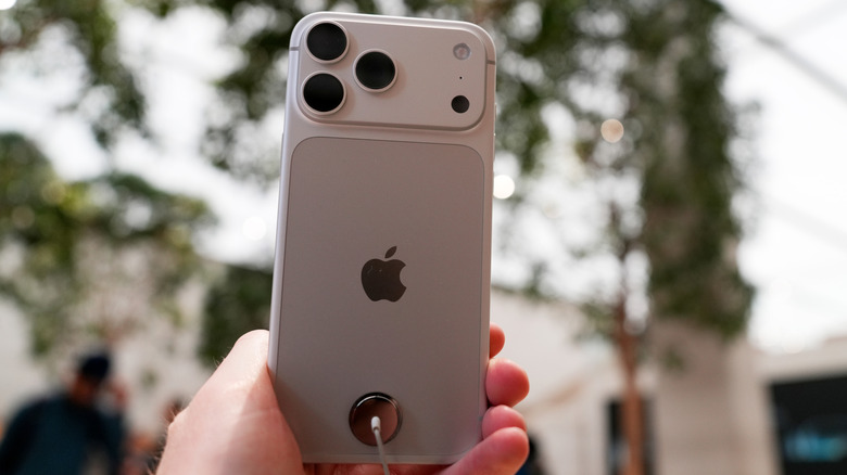 Person holding an iPhone 18 Pro outside.