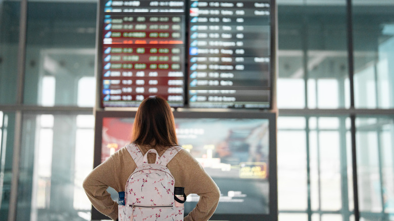 Looking at a departures/arrivals board at an airport