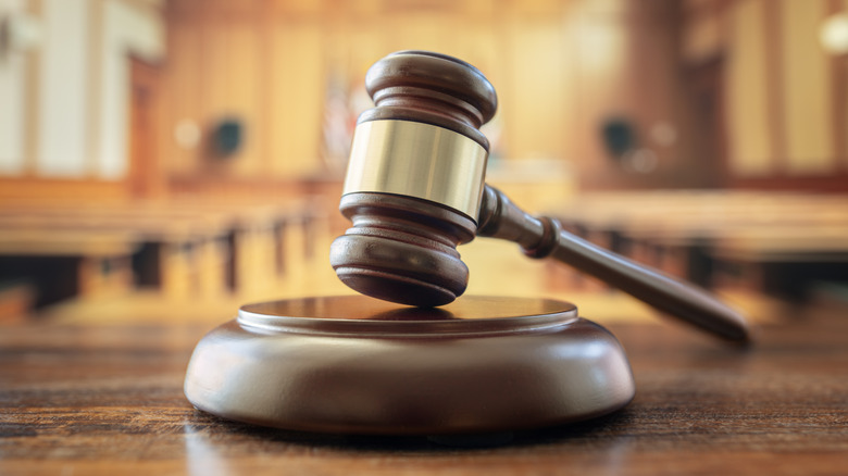 a legal gavel with a courtroom behind it