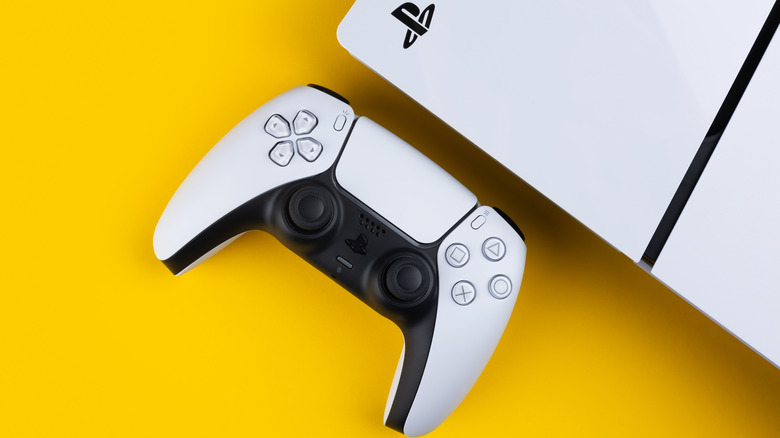 A PlayStation 5 console and controller on a yellow background