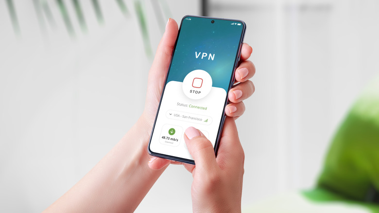 person holding a smartphone with an active VPN app
