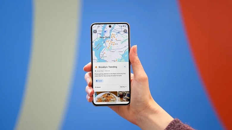 Hand holding phone showing Google Maps with trending lists