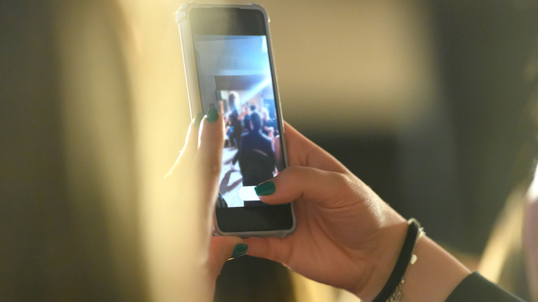 Person recording a video on a phone.