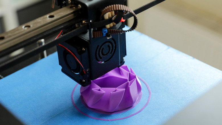 A 3D printer printing a purple geometric shape