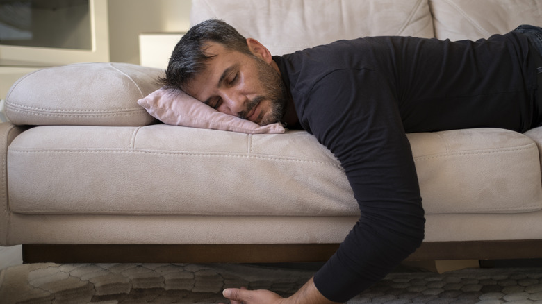 A man sleeping on a sofa.