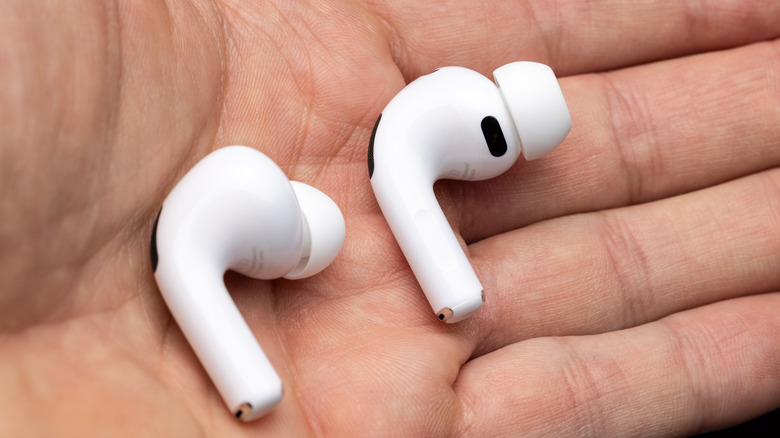 A person holding a pair of AirPods Pro 3.