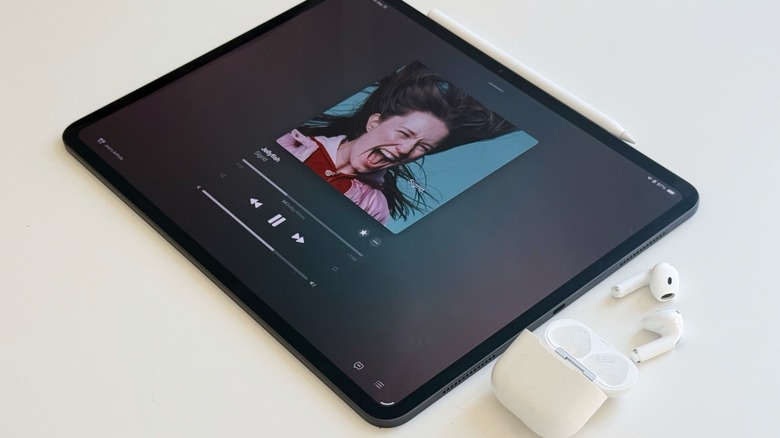 AirPods 4 outside of the charging case alongside the M4 iPad Pro