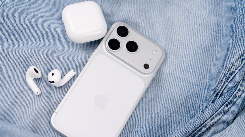 AirPods next to an iPhone 17 Pro, on top of a pair of jeans.