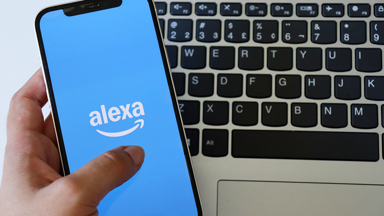 The Alexa app from Amazon open on a smartphone with a keyboard behind it