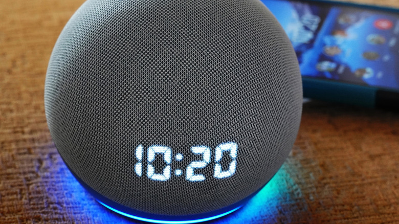 An Amazon Echo on a table near a smartphone
