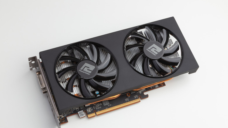 Old AMD GPU laying on a white flat surface showing fans