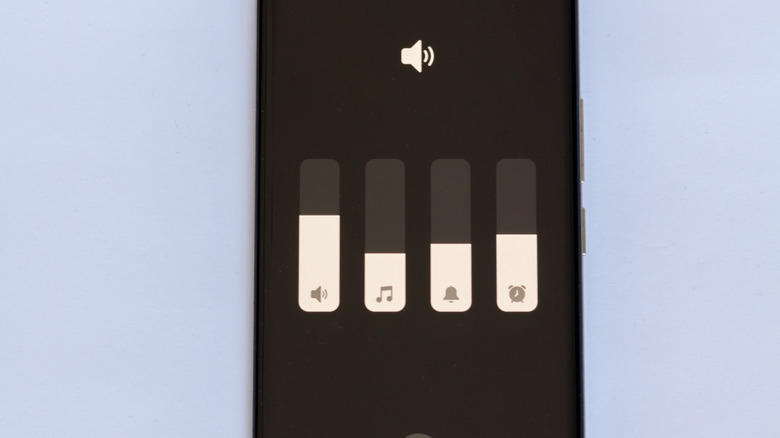 Close-up of volume sliders on smartphone showing different levels.