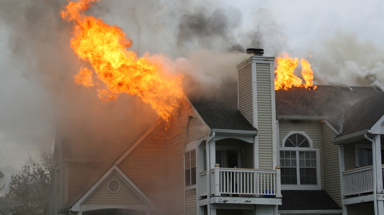 A house on fire with flames coming out of the roof