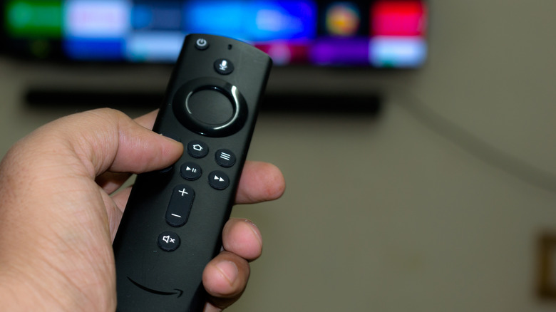 a hand holding the remote for the Amazon Fire TV Stick