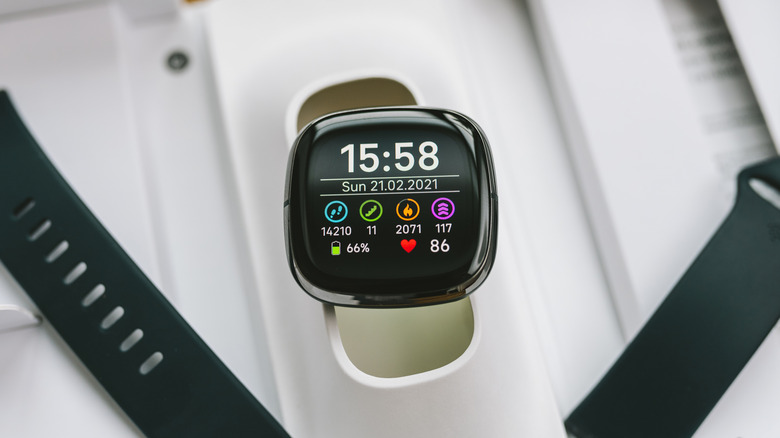 A fitness tracker displaying the time and various fitness statistics on its screen