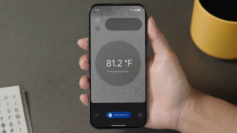 A hand holding a Google Pixel, the display showing a temperature reading.