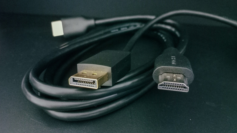 A bundle of HDMI cables looped, against a black background.