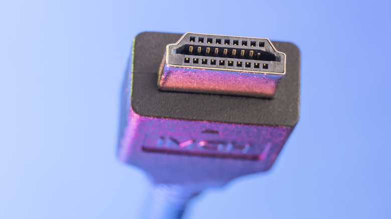 An HDMI cable against a blue-purple background.