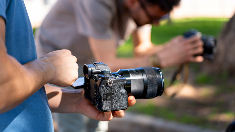 Photographers shooting a nature scene with DSLRs.