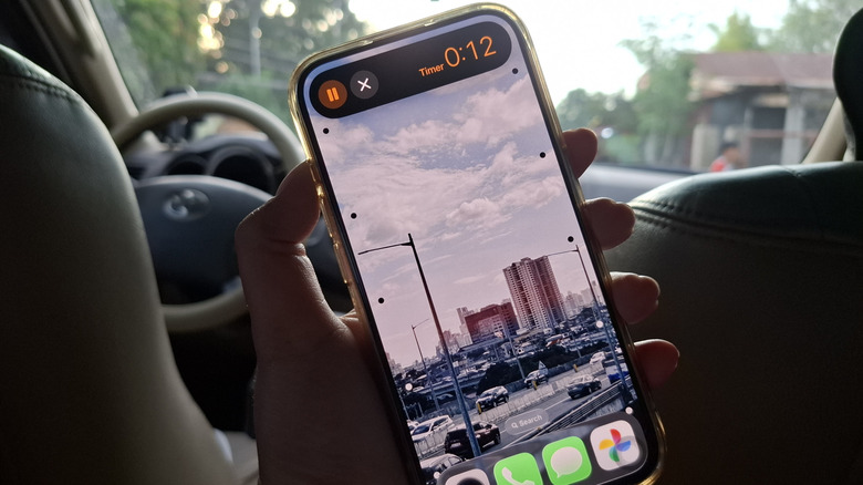 Hand holding iPhone showing timer running