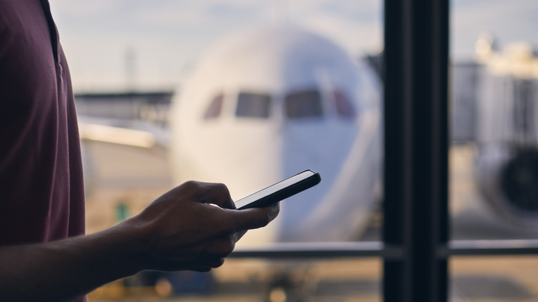 Person checking phone at airport