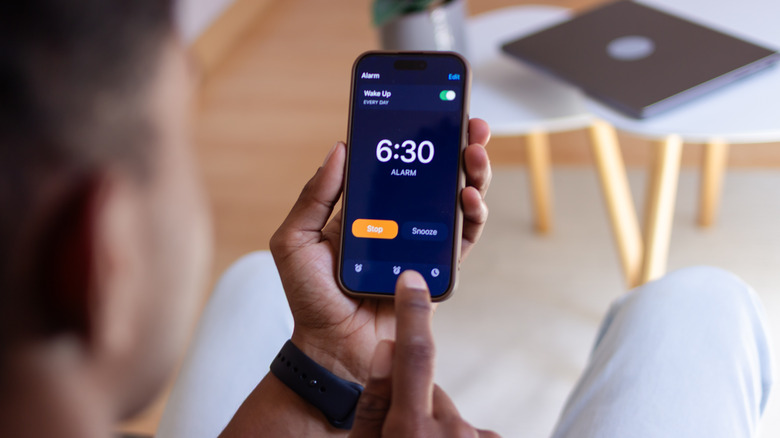 Looking over the shoulder of a man at an iPhone alarm