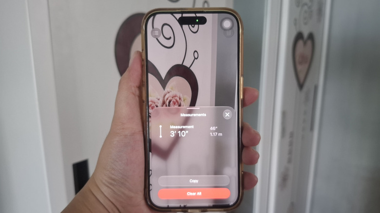 Hand holding iPhone showing Measure app with a 46" measurement