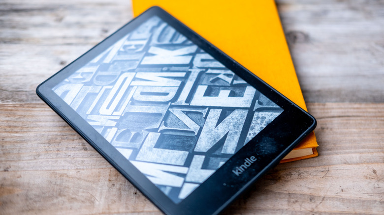 A Kindle reader on top of a notebook.