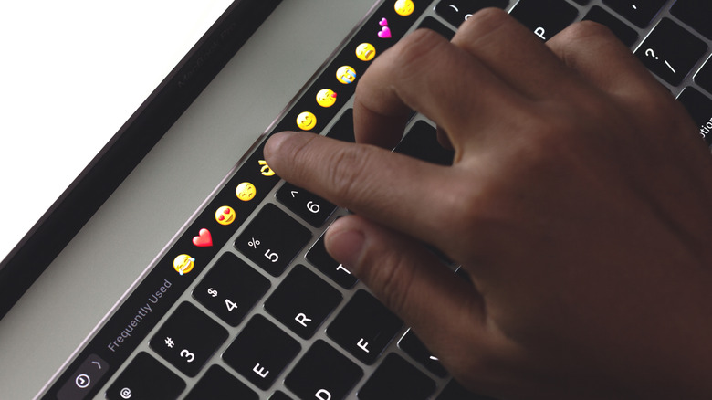 Close-up hand touching on touch bar on new macbook pro