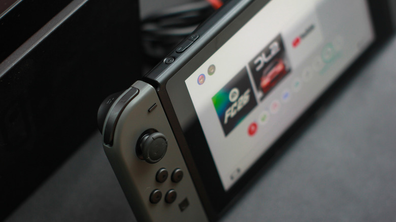 Close up of the original Nintendo Switch in front of its charging dock.
