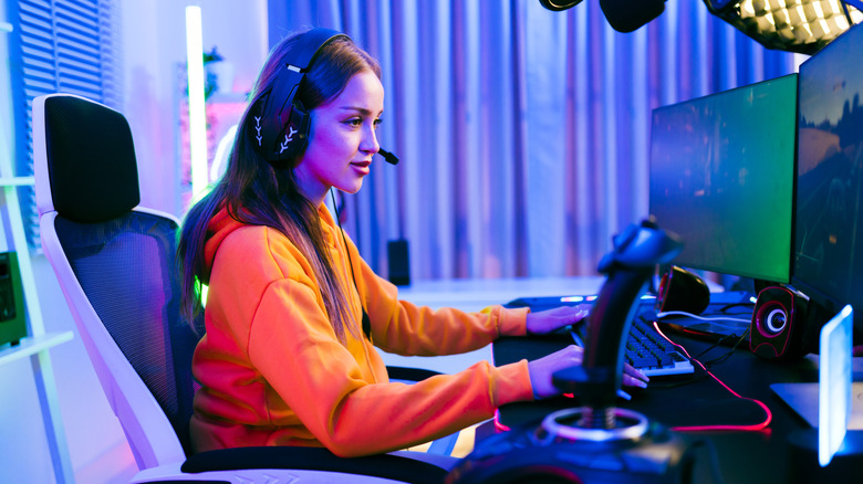 Woman playing a PC game with a headset on