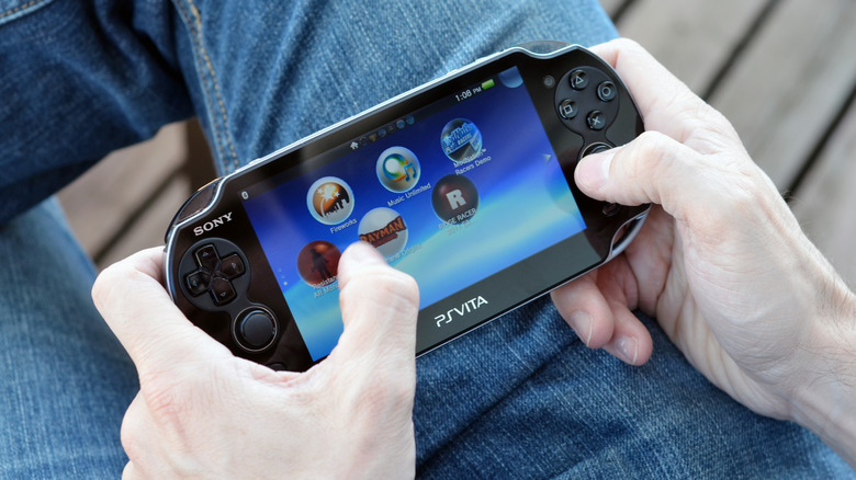 Man playing a PlayStation Vita handheld