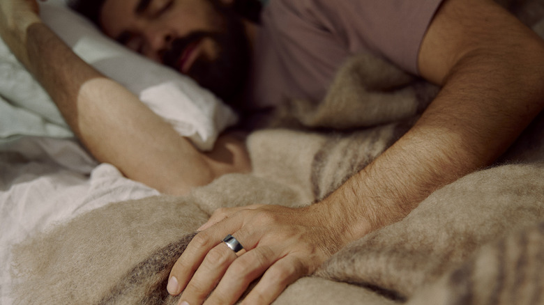 A man sleeping while wearing an Oura Ring.