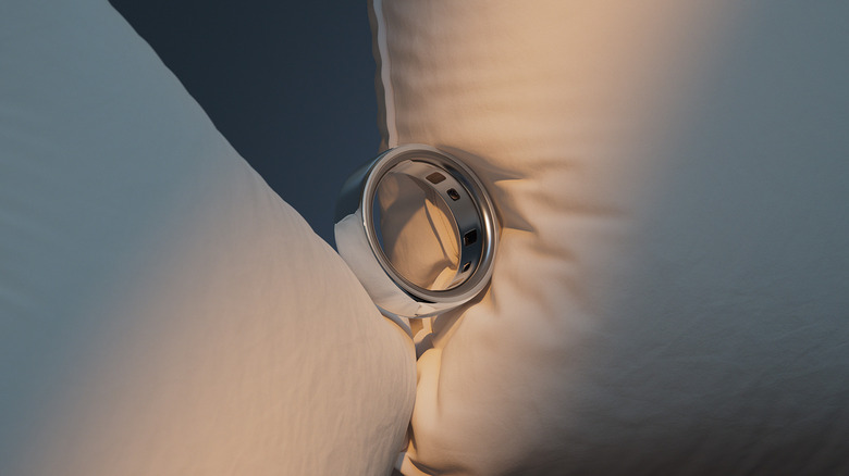 An Oura Ring wedged between two pillows.