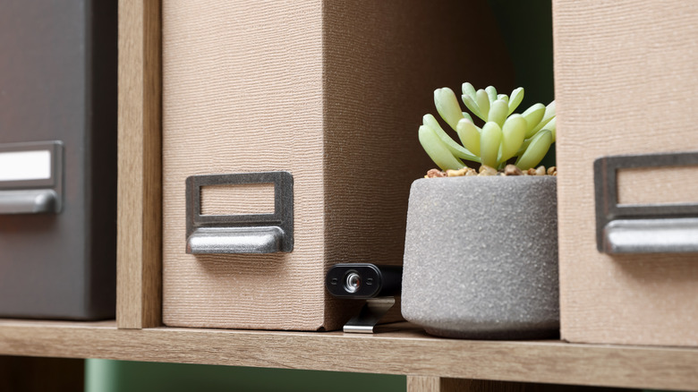 A spy camera placed on a shelf.