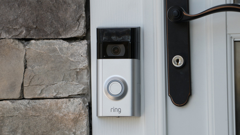 A closeup of a Ring camera attached to the frame of a door