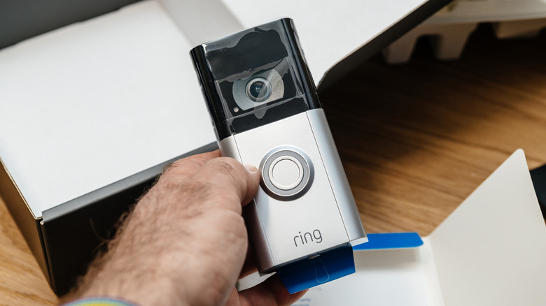 An individual holding a Ring camera
