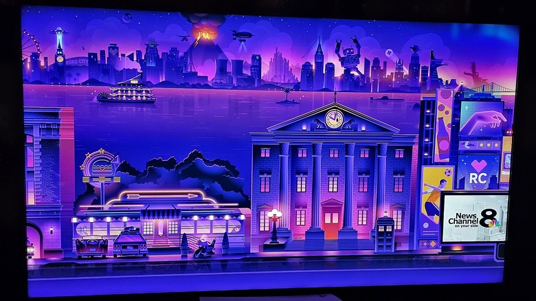 Roku City image is displayed on a Hisense Roku TV with screensaver active.