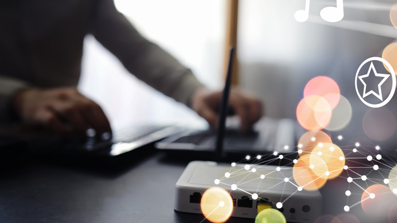 A person configures internet settings with a router and other network devices sitting nearby