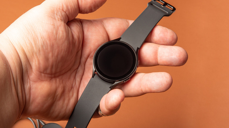 Person a Samsung Galaxy Watch 4 with a black screen
